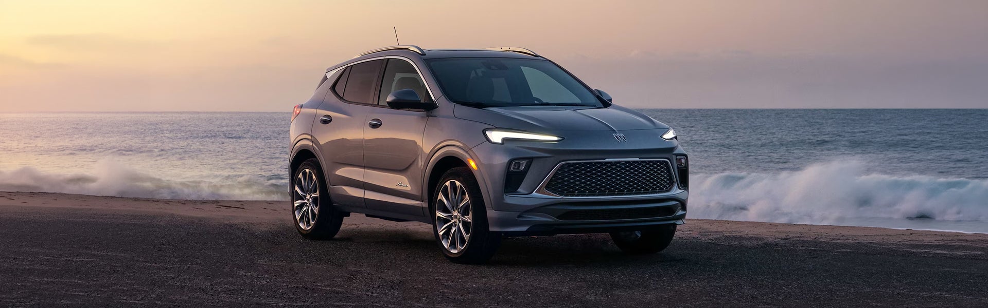 2026 Buick Encore GX driving through a palm tree-lined neighborhood